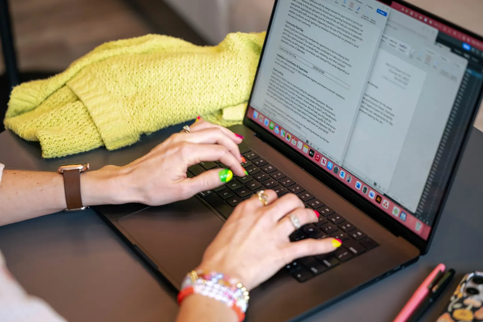 Hands typing on a laptop while writing a placemaking grant